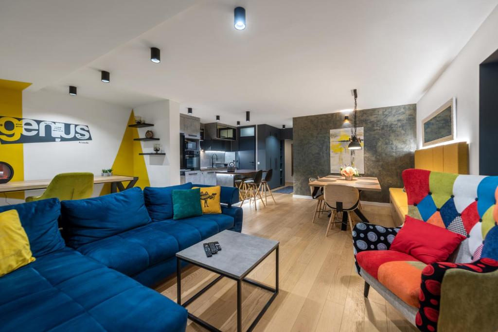 a living room with blue couches and a kitchen at Noble park in Zagreb