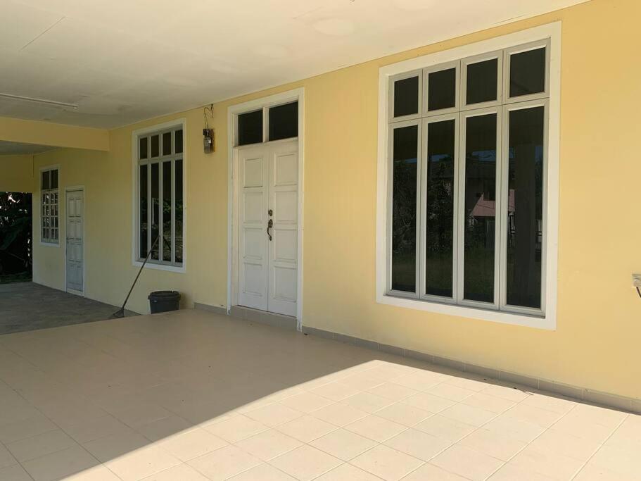 an empty house with a door and windows at Homestay Docmac Wakaf Che Yeh in Kota Bharu