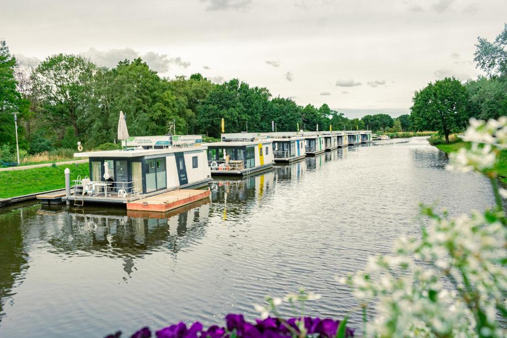 una fila di piccole imbarcazioni ormeggiate su un fiume di HB 5 - Hausboot Bad Bederkesa a Bad Bederkesa