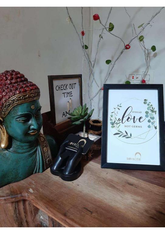 une photo d'une statue verte sur une table avec une photo dans l'établissement Royal Gharana, à Jaisalmer