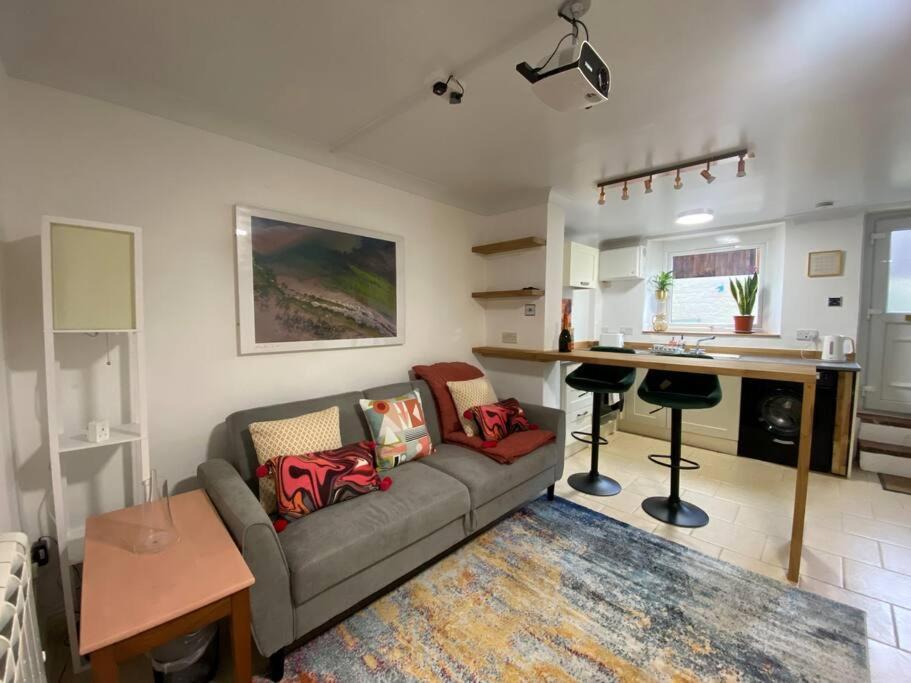 a living room with a couch and a kitchen at Neptune's Nook, Cromer in Cromer