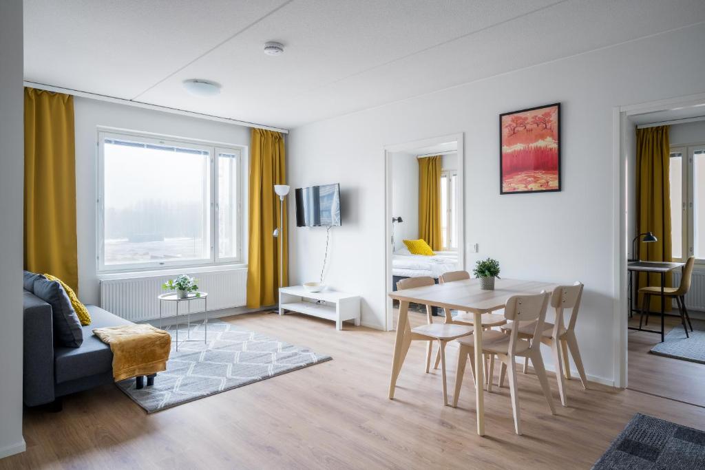 uma sala de estar com uma mesa e um sofá em Hiisi Homes Espoo Finnoo em Espoo