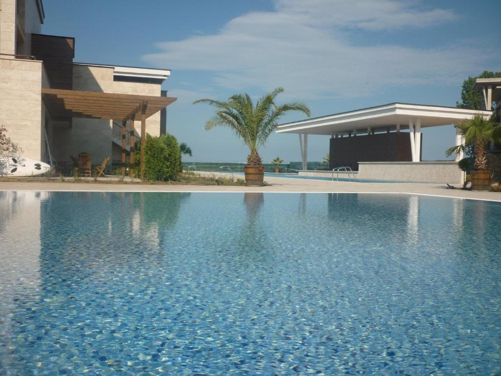 a swimming pool in front of a house at Apolonia Resort Apartments in Sozopol