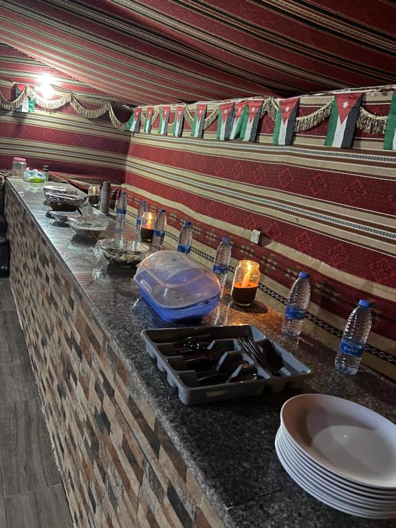 a counter top with plates and dishes on it at Wadi Rum Candles Camp in Wadi Rum