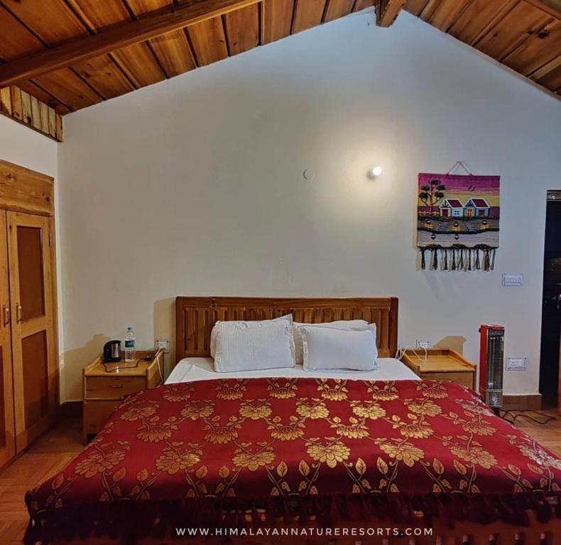 a bedroom with a large bed with a red bedspread at Misty Heaven in Harsil