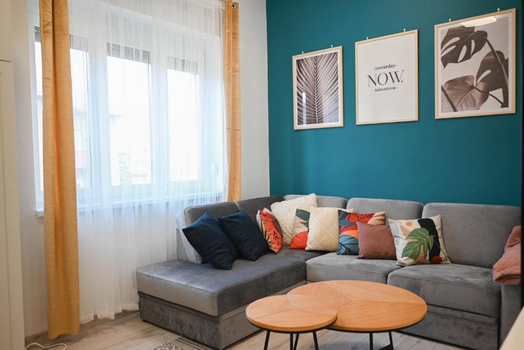 - un salon avec un canapé et une table dans l'établissement Petőfi Apartman Pécs, à Pécs