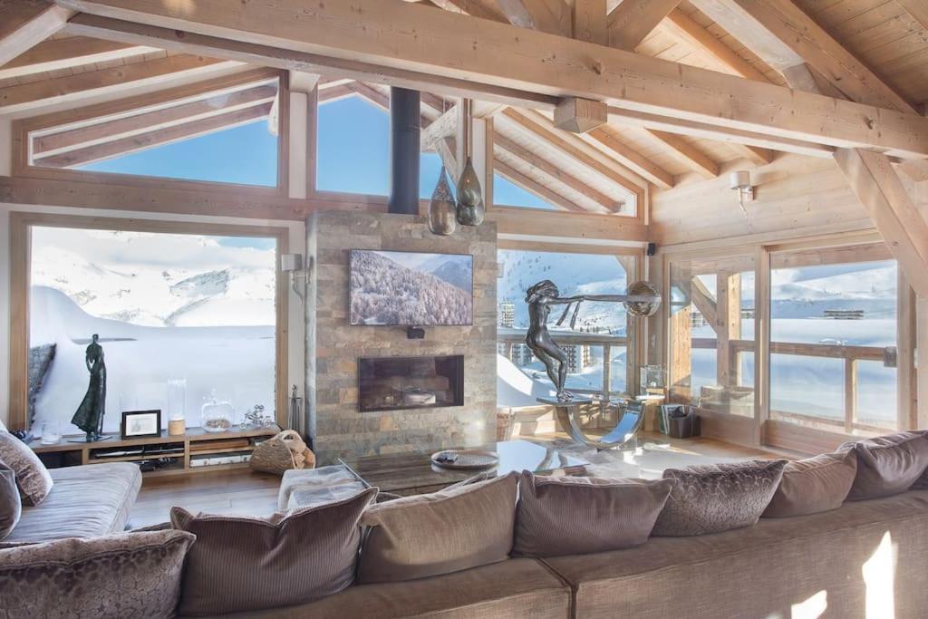 a living room with a large couch and windows at Chalet Opale in Tignes