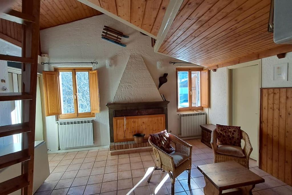 a living room with a fireplace and a table and chairs at Il Covo delle Regine in Abetone