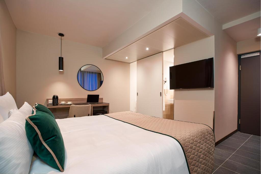 una camera d'albergo con letto e scrivania di Leonardo Hotel Vienna Otto-Wagner a Vienna