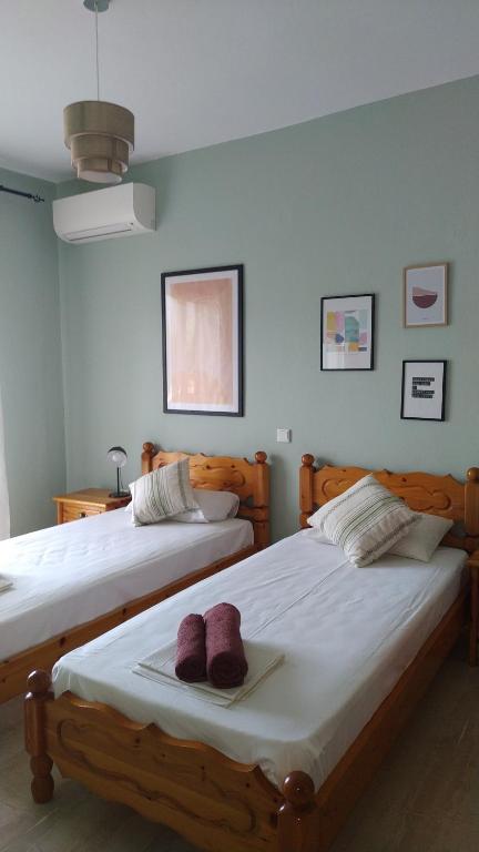 2 letti in una camera da letto con 2 asciugamani viola di Dassia Green Apartments a Dassia