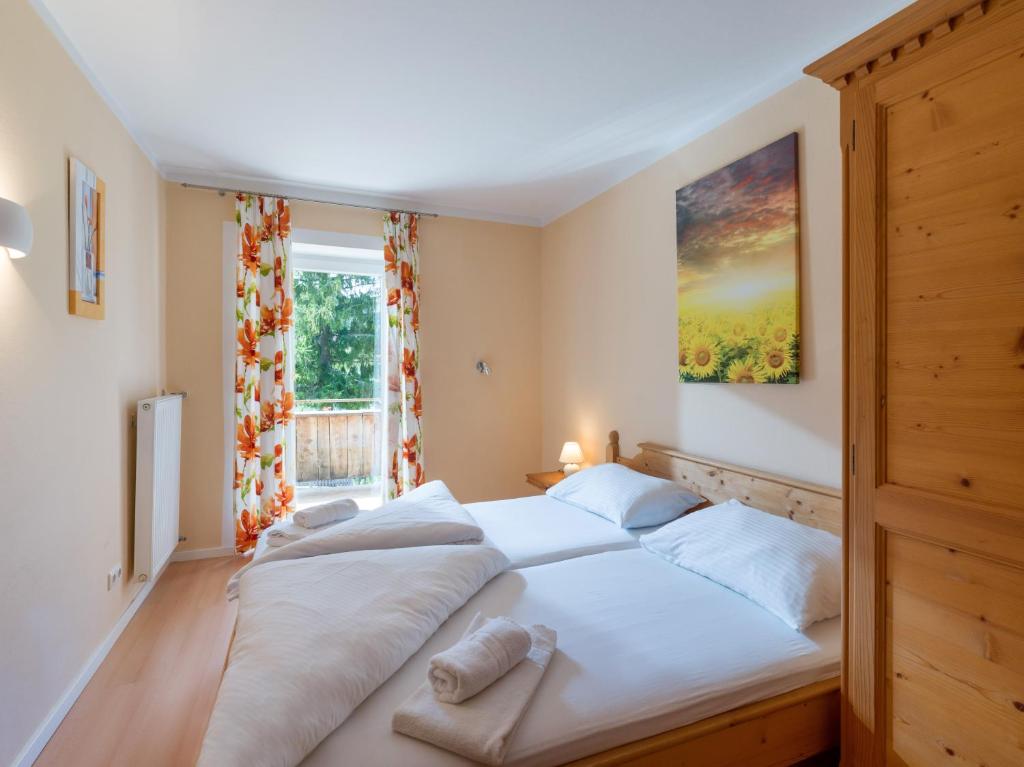 a bedroom with a large white bed in front of a window at Familienfreundliche Ferienwohnung im Thierseetal, FeWo 11 in Thiersee