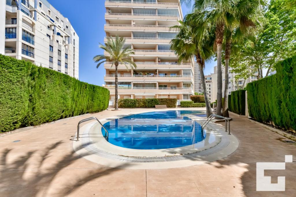 a swimming pool in front of a tall building at Apartamento Apolo XIX 34L - Grupo Turis in Calpe