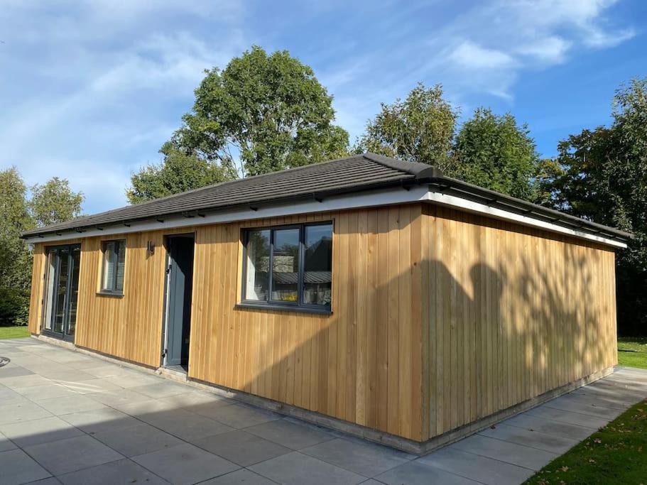 a small wooden building with a window at Cedar Garden Cottage in East Chinnock