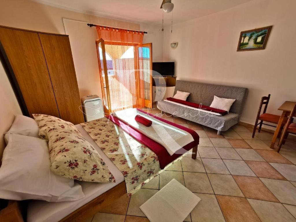 - un salon avec un lit et un canapé dans l'établissement Apartments Rukelj, à Karlobag