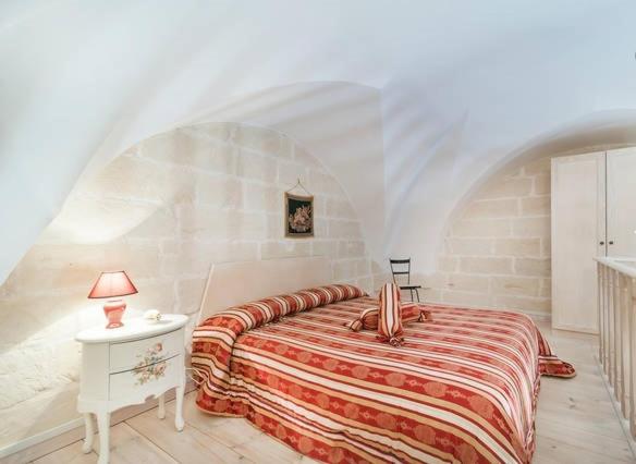 - une chambre avec un lit et une table avec une lampe dans l'établissement B&B La Casetta, à Cavallino di Lecce
