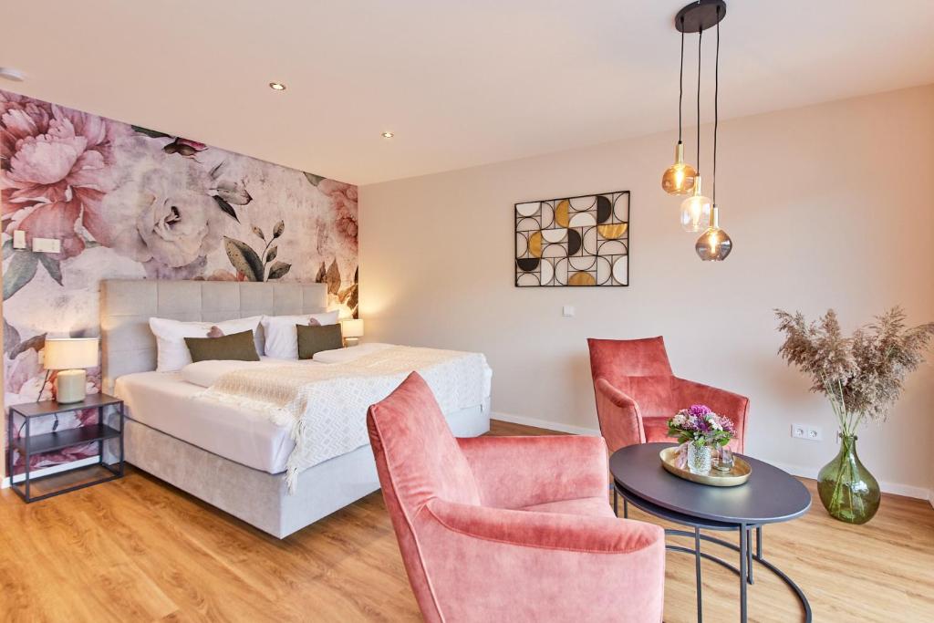 a bedroom with a bed and a table and chairs at Luxus Apartments Mosel-Zeit NEU 2023 in Zell an der Mosel