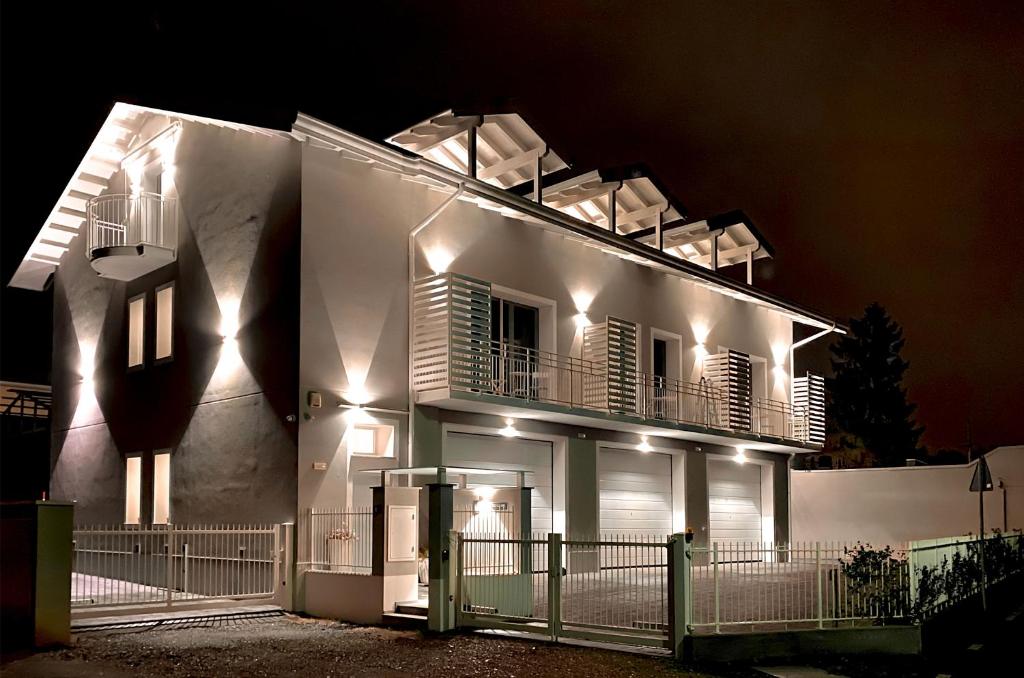 a white house with a balcony at night at B&B Quattro Stagioni Charme and Wellness in Besnate