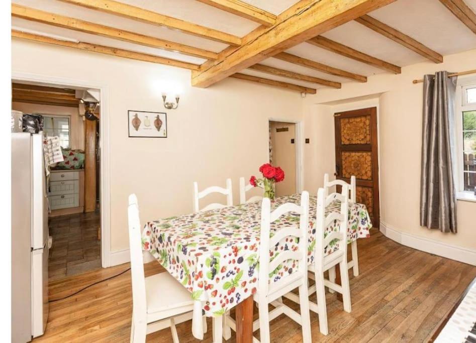 a kitchen and dining room with a table and chairs at Cosy Cottage in Knottingly
