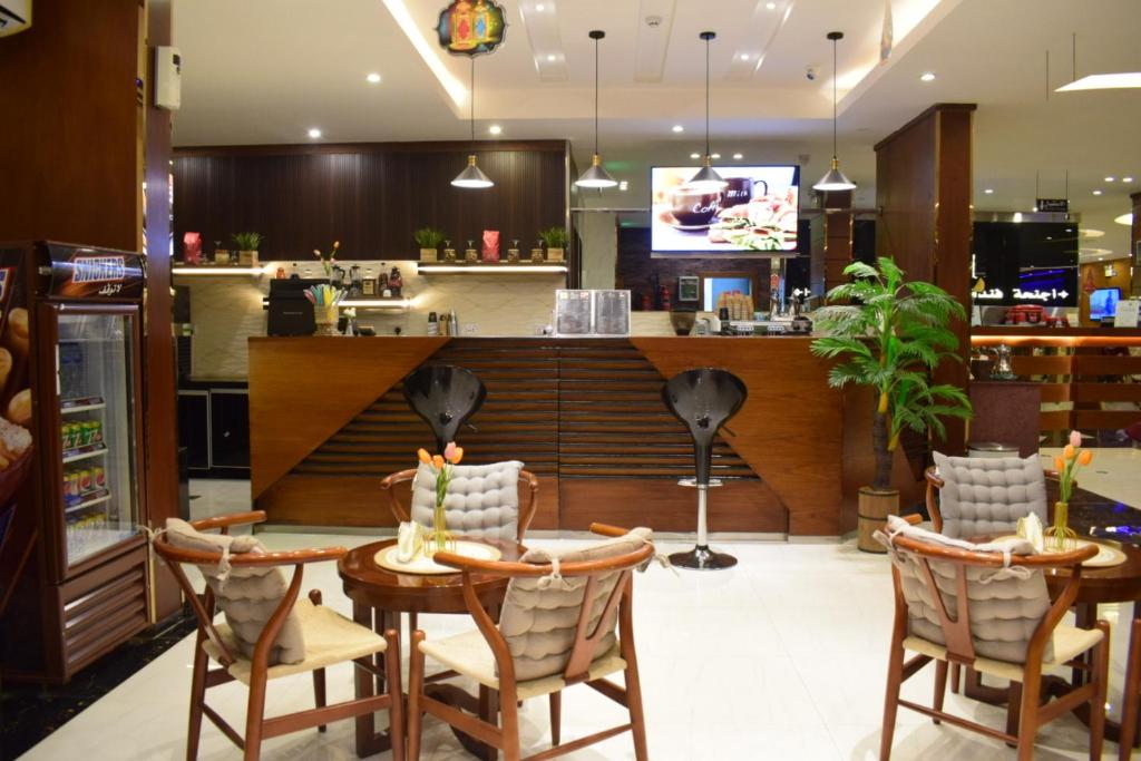 un restaurant avec une table, des chaises et un comptoir dans l'établissement Aral Hotel Apartments, à Tabuk