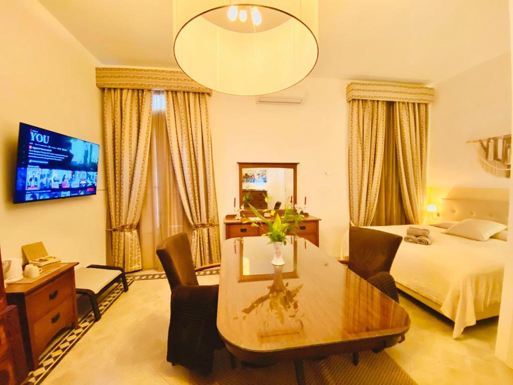 a hotel room with a bed and a table and chairs at The Maltese Sun in Sliema