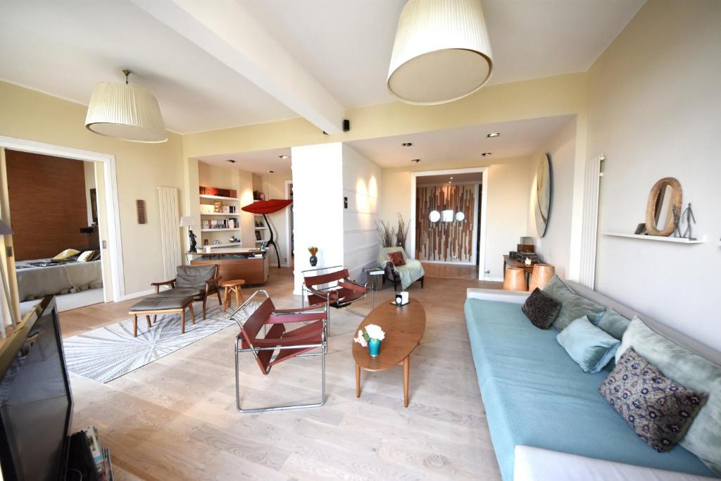 un salon avec un canapé bleu et des chaises dans l'établissement MV Gallery Collection, Beau Bourgeois vue Mer, à Cannes