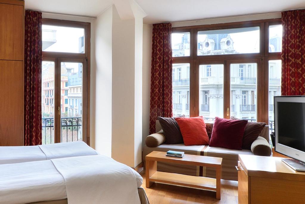 a hotel room with a couch and a tv at Le Palace Hotel in Thessaloniki