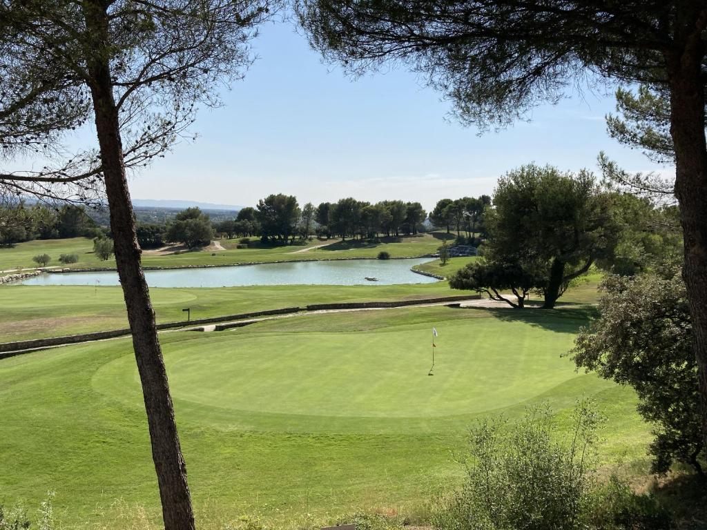 a view of a golf course with a pond at Magnifique Vue CLIM LINGE Golf Saumane 6P Piscine Tennis in Saumane-de-Vaucluse