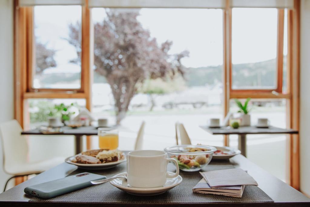 un tavolo con piatti e una tazza di caffè di Hostería El Coirón a Esquel