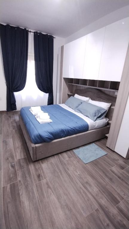 1 dormitorio con 1 cama con sábanas y cortinas azules en Appartamento Fiore Roma San Pietro, en Roma