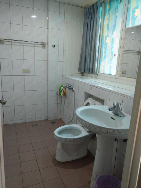 La salle de bains est pourvue de toilettes et d'un lavabo. dans l'établissement 煌家民宿, à Jinhu