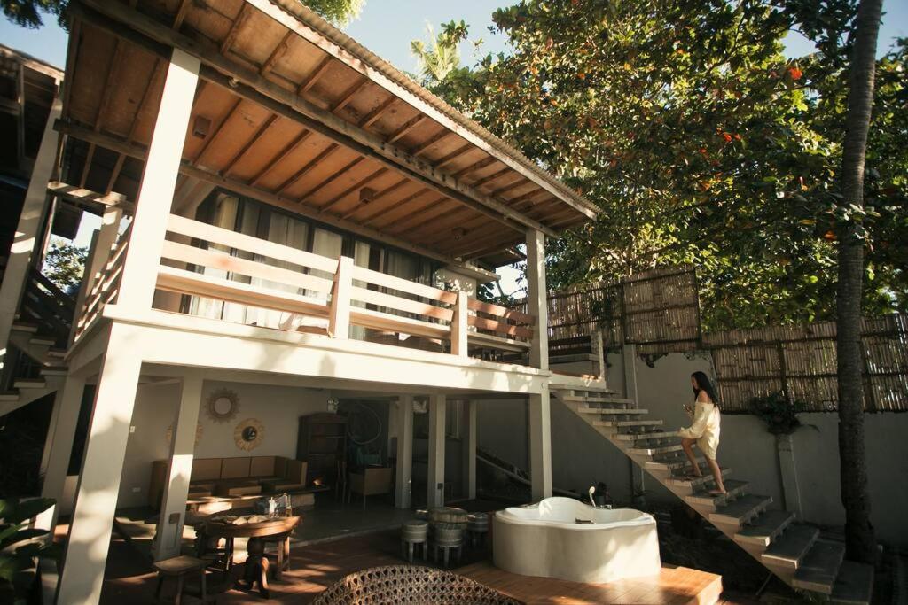 a woman walking up the stairs of a house at Exclusive Beachfront Villa w/ Outdoor Tub & Kayaks in Sabang