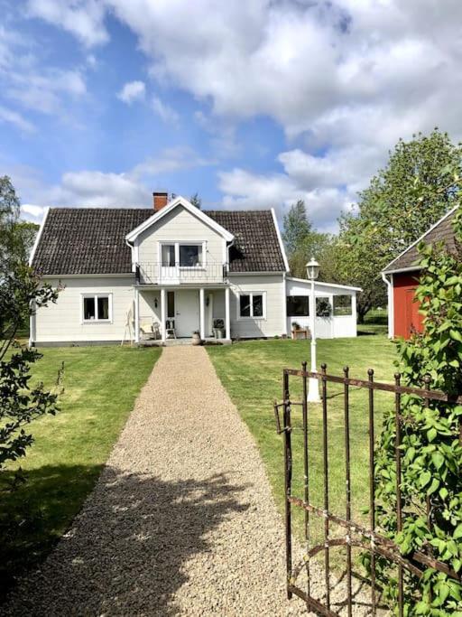Biały dom z płotem na podwórku w obiekcie Mysigt hus med utsikt över Östgötaslätten w mieście Vikingstad