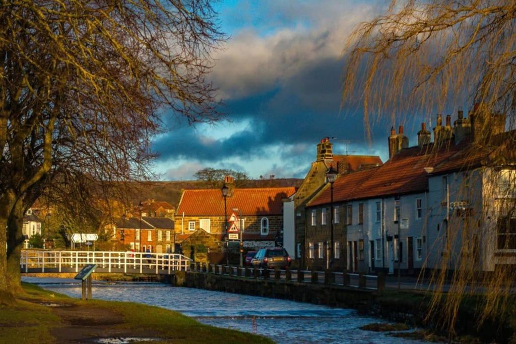 a town with houses and a river and a fence at The Old Dairy in Great Ayton