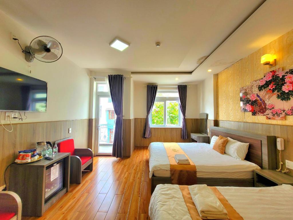 Habitación de hotel con 2 camas y TV en Dalat Holiday Hotel, en Da Lat