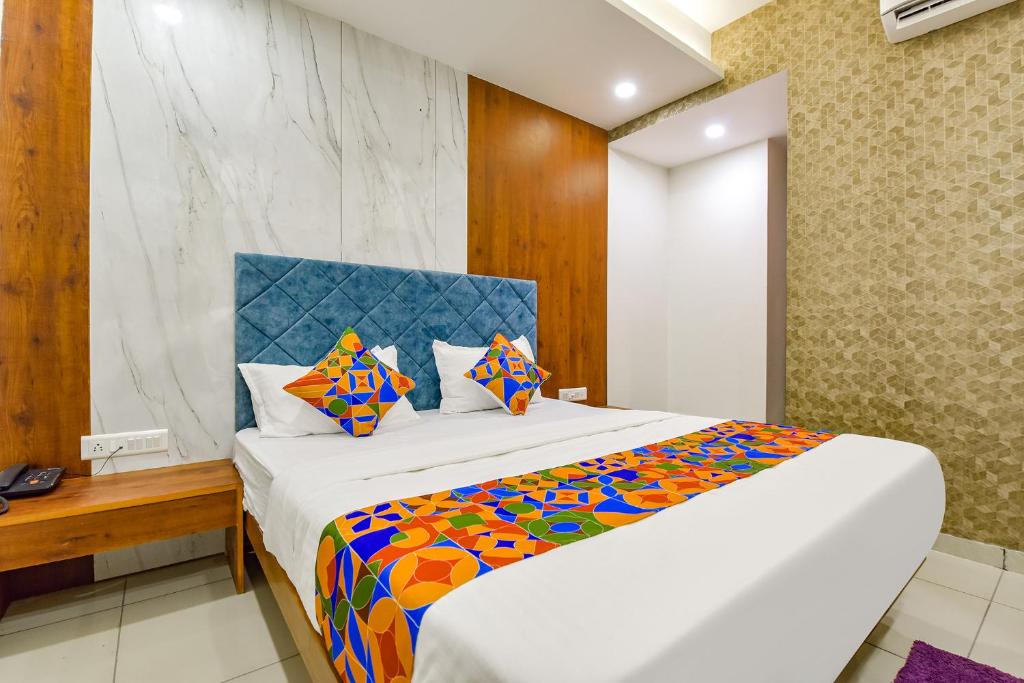 a bedroom with a large bed with a colorful blanket at FabHotel Elite Inn I in Ahmedabad