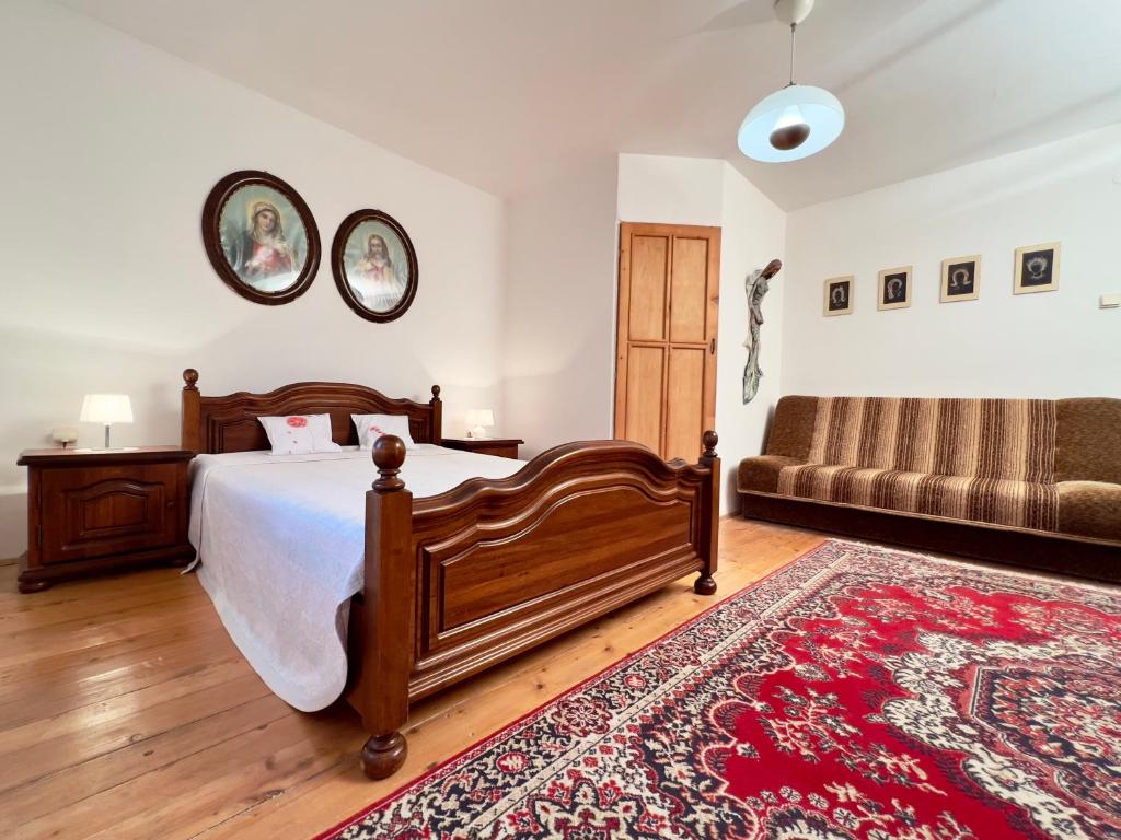 1 dormitorio con cama, sofá y alfombra en AEDA chalupa en Liptovské Sliače
