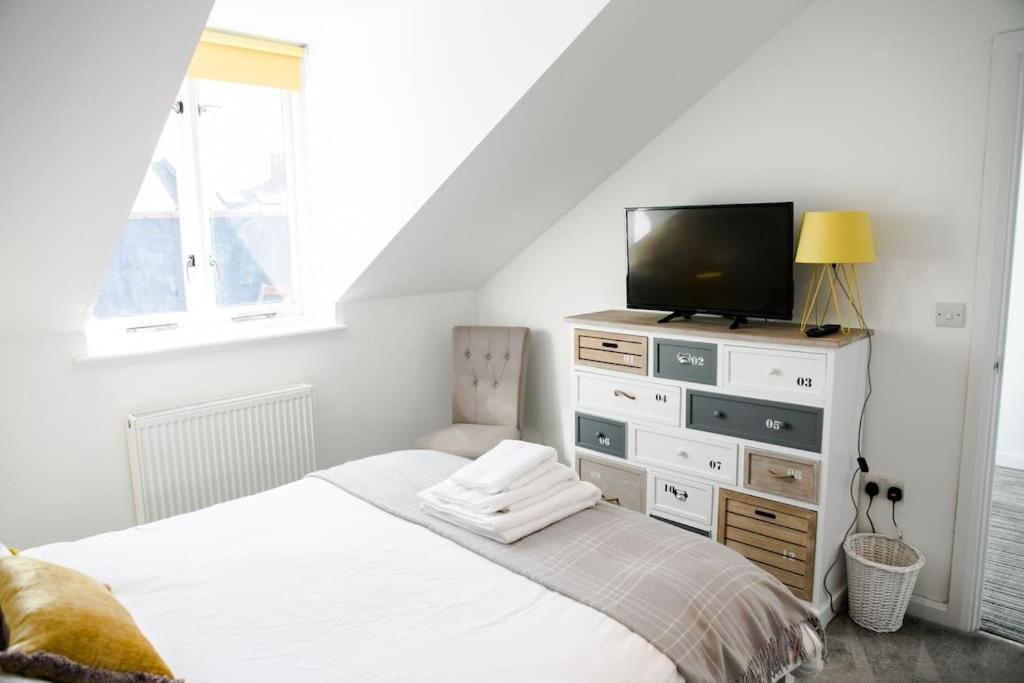 a bedroom with a bed with a tv and a dresser at 'Hidden Jewel' city centre + FREE PARKING in Plymouth