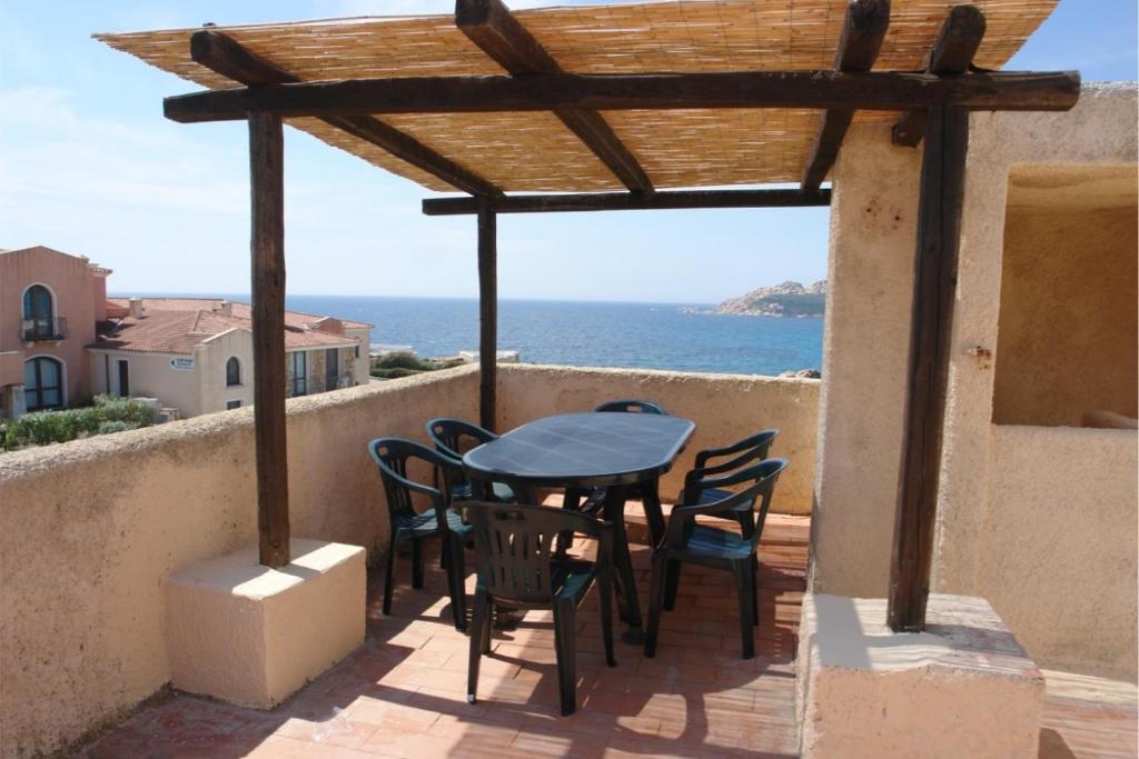 een tafel en stoelen op een balkon met uitzicht op de oceaan bij Primavera Apartments in Capo Testa
