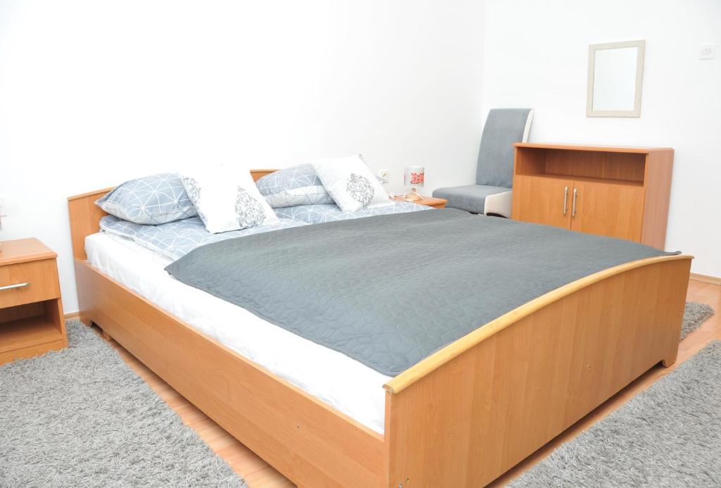 a bedroom with a large bed with a wooden frame at Apartment with parking in the free garage in Sarajevo