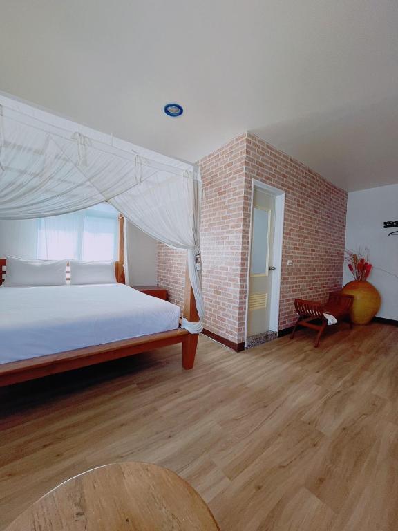 a bedroom with a bed and a brick wall at Blue Sea Inn in Eluan