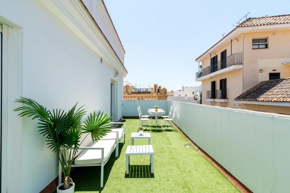 uma varanda com cadeiras e uma mesa num edifício em Casa Palacio Sanlúcar de Barrameda em Sanlúcar de Barrameda