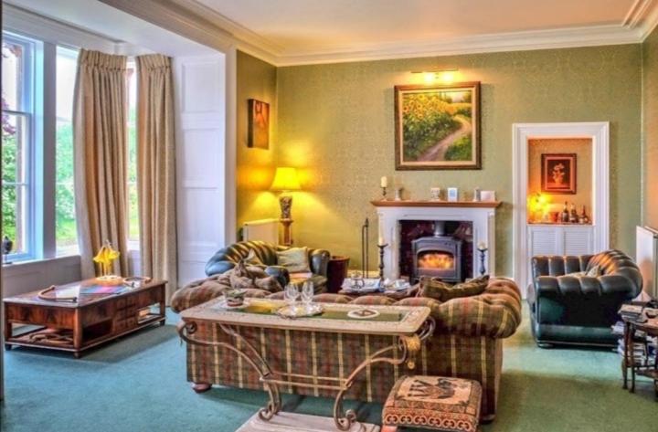ein Wohnzimmer mit Möbeln und einem Kamin in der Unterkunft The Gables Luxury Bed & Breakfast in Duddo