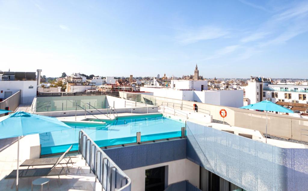 a building with a swimming pool on top of it at Hotel Macià Sevilla Kubb in Seville