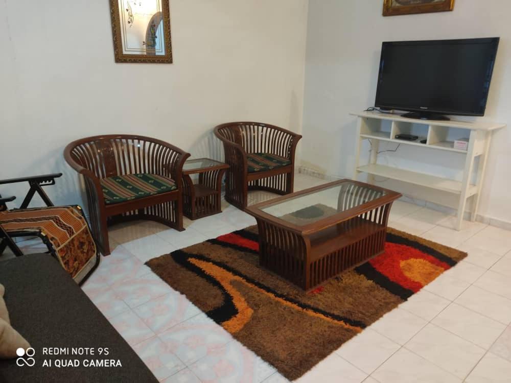 a living room with four chairs and a tv at R&R HOMESTAY in Simpang Renggam