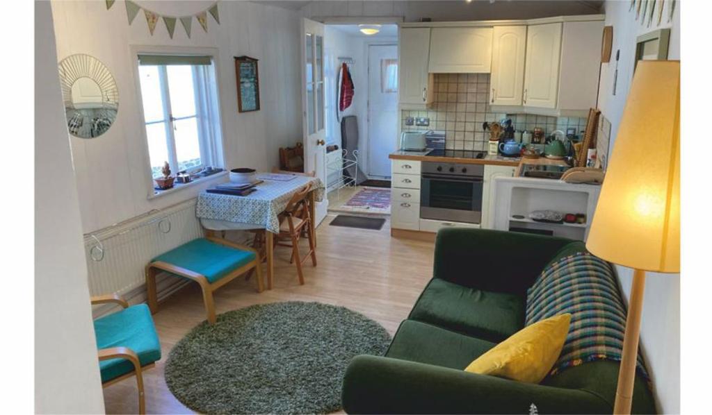 a living room with a green couch and a kitchen at The Sail Loft in Lostwithiel