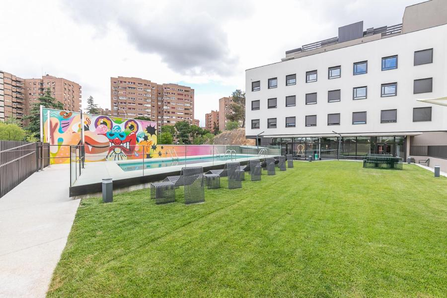 a park in front of a building with a mural at micampus Madrid Sinesio Delgado Student Residence in Madrid