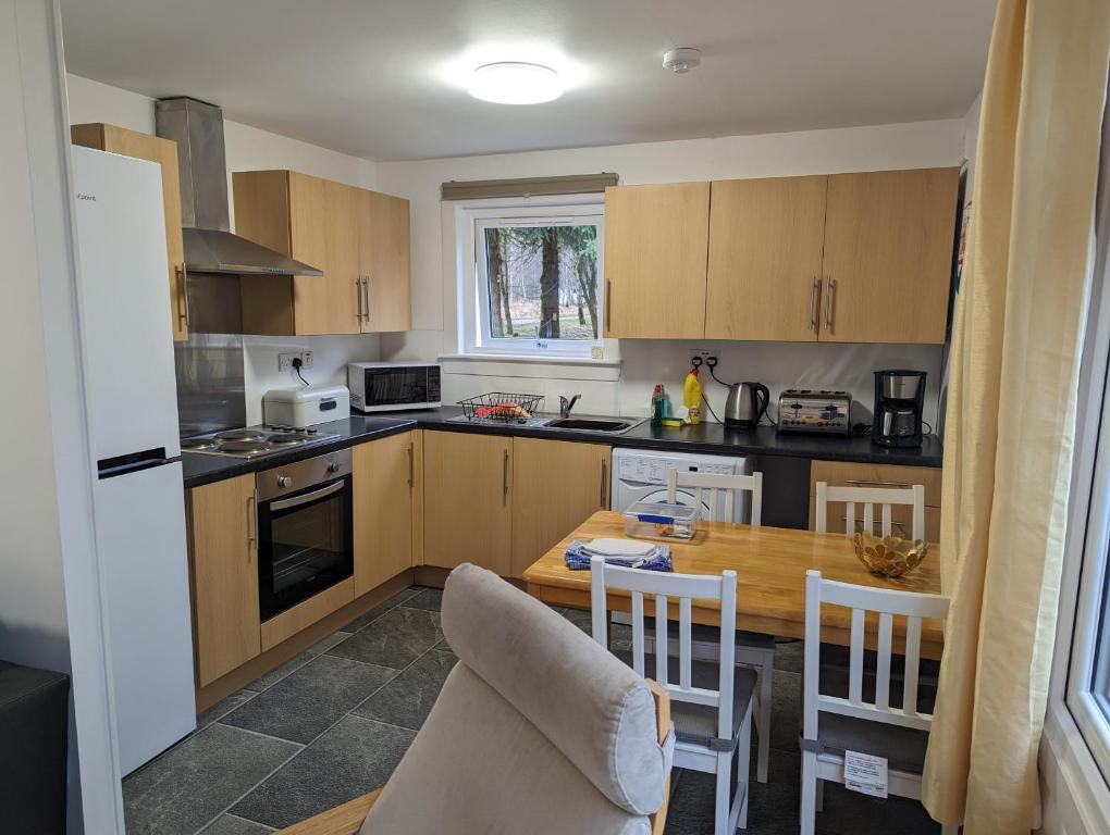 a kitchen with a table and a dining room at The Little Houses in Roybridge