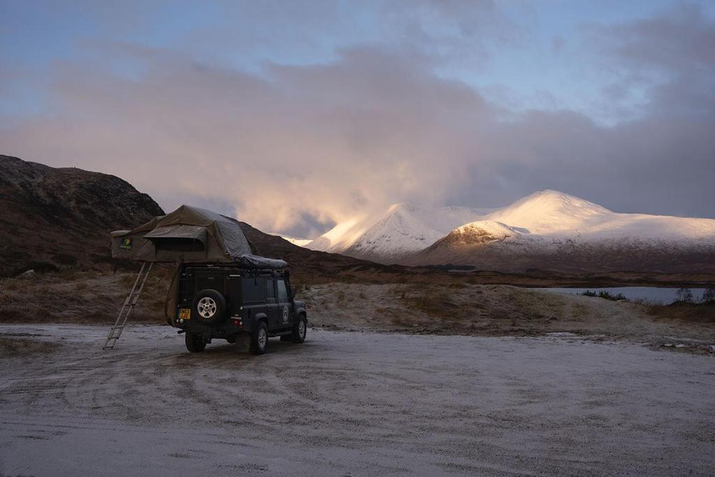 Ein Jeep mit einem Unterstand an der Seite eines Berges in der Unterkunft Land Rover Defender Luxury Camper in Morpeth