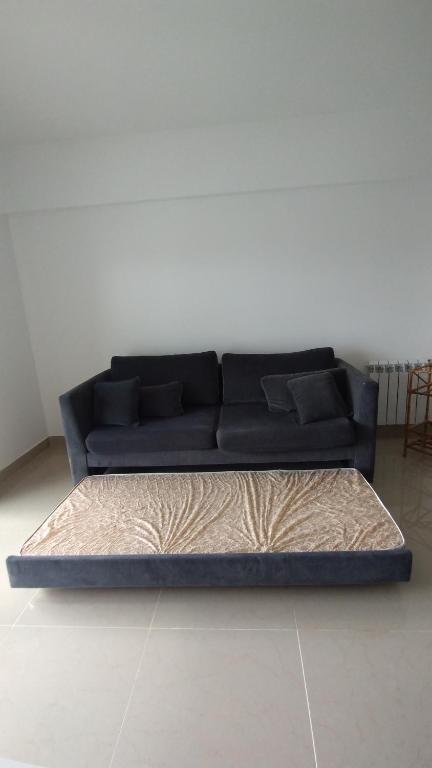 un sofá azul sentado en una sala de estar en Azucena Apart II en Salta