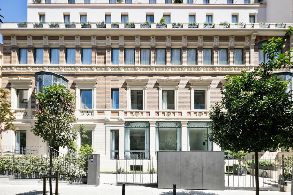 a large white building with a sign on it at Murmuri Residence Mercader in Barcelona